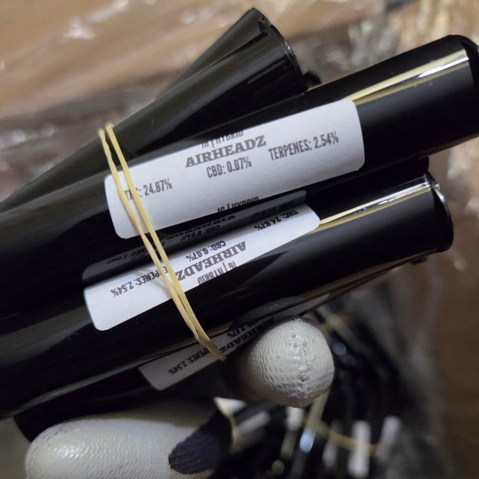 Three black and gold cosmetic tubes with visible branding on a textured surface.