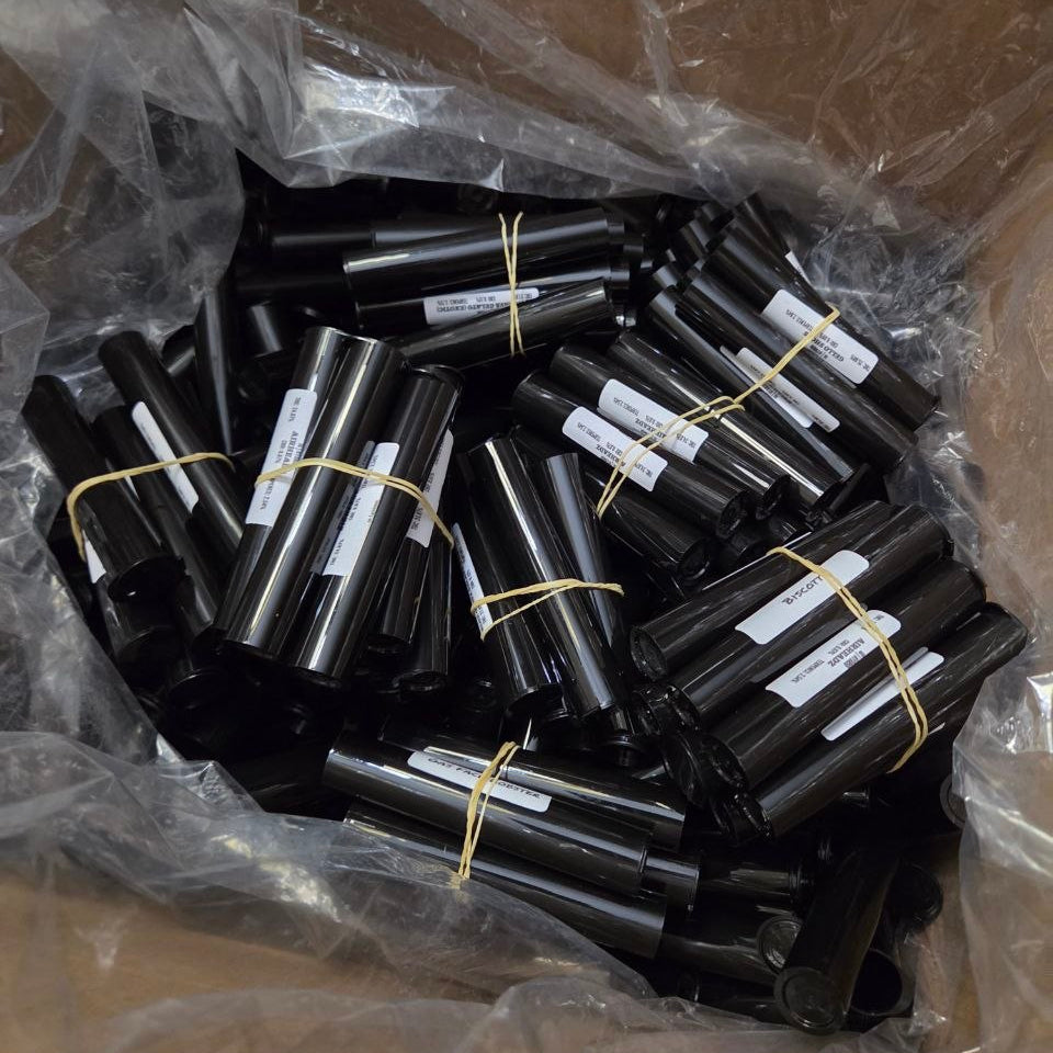 Collection of black cylindrical objects with labels in a clear plastic bag.