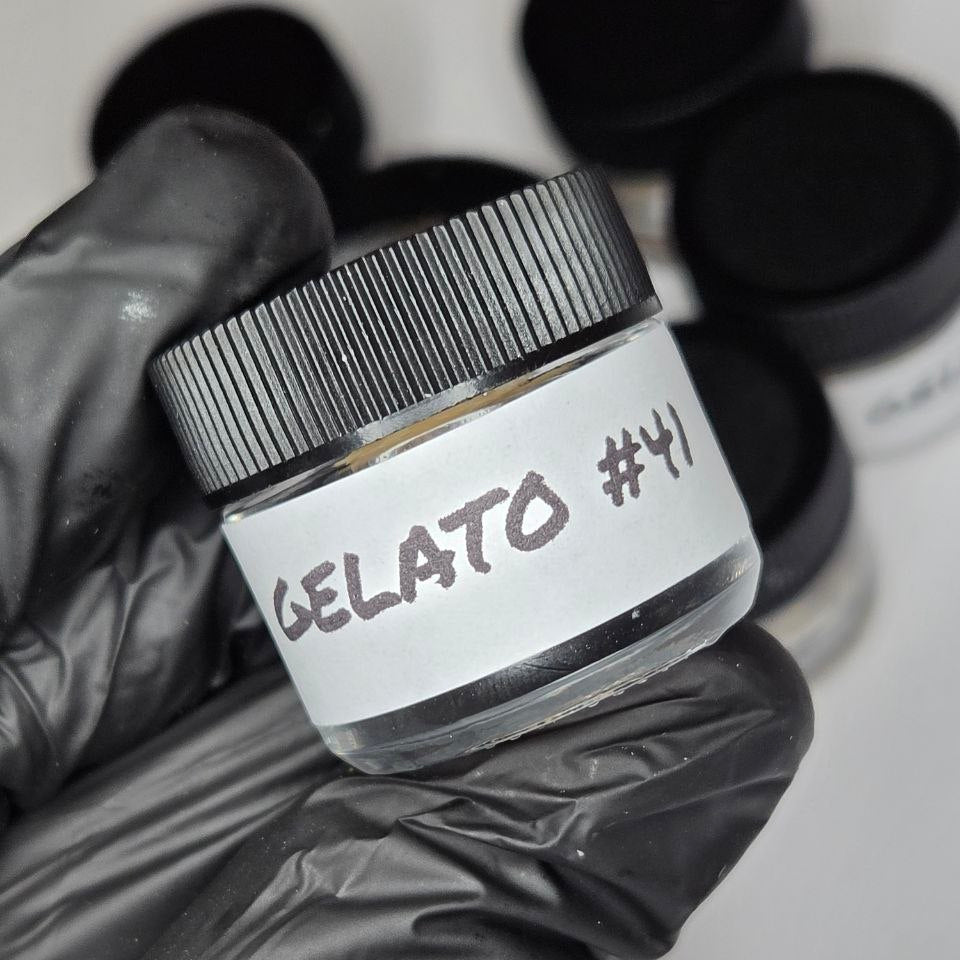 Jar labeled 'Gelato #41' held by a gloved hand with blurred background
